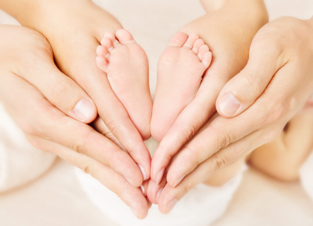 Newborn baby feet parents holding in hands.